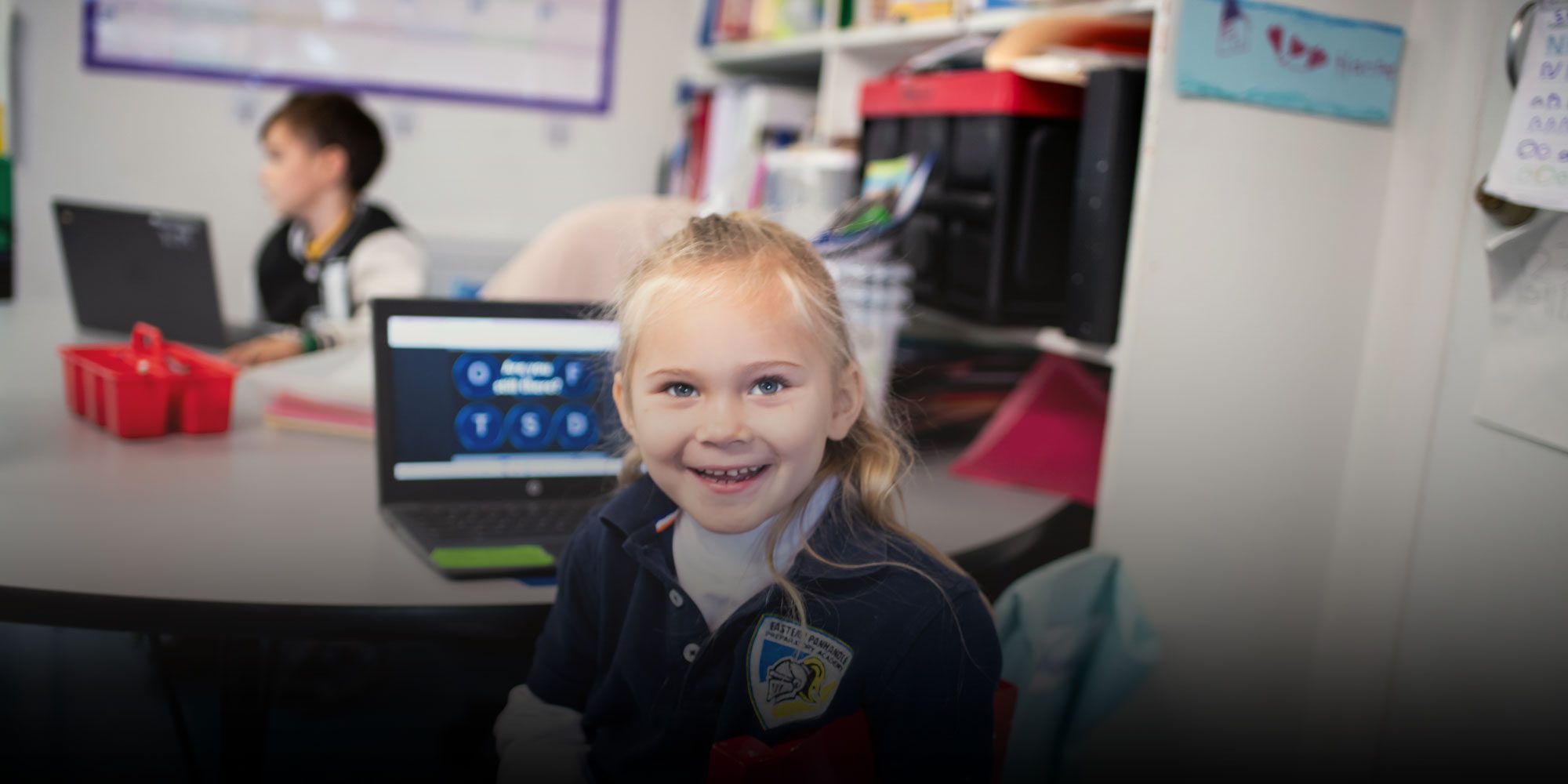 Smiling elementary student working on computer
